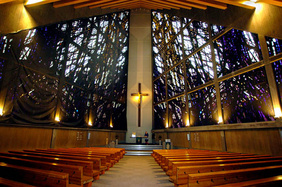 Wunderschön: Der dreieckige Innenraum der Stephanuskirche. Die Kerzen auf dem Altar werden mit Petroleum gefüttert, weil die eigenwillige Thermik normale Wachskerzen einfach ausbläst.