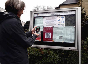 Pfarrer Peter Schmidt macht’s vor: Plakat suchen, QR-Code einscannen und die kleinen Überraschungen diesmal digital genießen. 