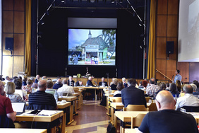 Plenarsaal in Rotthausen: Pfarrer Dr. Uwe Gerstenkorn (rechts am Rednerpult) stellte die Bude zur Werbung für den Kirchentag 2019 in Dortmund vor.