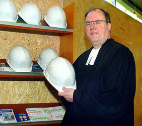 Pfarrer Hagen Schillig greift zum Helm, um sich auf der "Baustelle Bürgerzentrum" umzusehen. „Sich gemeinsam auf den Weg zu machen, finde ich richtig gut!“ PHOTO: CORNELIA FISCHER