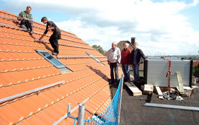 Hoch auf dem Dach des Evangelischen Jugendheimes: Pfarrer Dr. Uwe Gerstenkorn, Joachim Zausch und Hartmut Schmirgel (von rechts) schauten am 15. September bei der Installation der ersten Solarmodule zu. FOTO: CORNELIA FISCHER