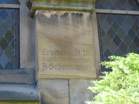 Der Name von August Schumacher ist rechts neben dem Hauptportal der Kirche verewigt.