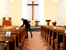 Auch Gemeindepfarrer Michael Schönberg verteilt die Ablaufzettel für den 1. Präsenzgottesdienst in der Kirche in Heßler mit dem gebotenen Abstand, immer nur ein Zettel pro Bankreihe.