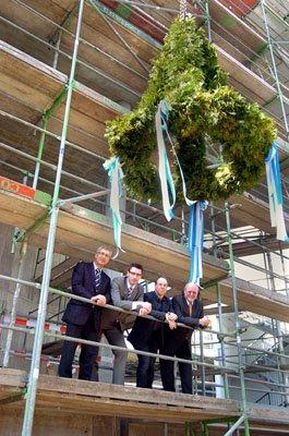 Im Gerüst und unter dem Richtkranz: (von links) Norbert Gottge (Geschäftsführung Fa. Zabel), Architekt Sven Berg, Thomas Schultheis (Technischer Leiter EVK) und Dr. Karl Bosold (Geschäftsführer EVK). FOTO: CORNELIA FISCHER
