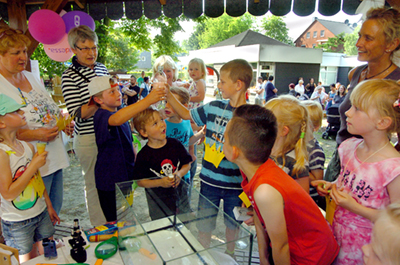 Auf dem Sommerfest experimentieren kleine Forscher neugierig mit Wasser und verstehen dabei spielerisch physikalische Phänomene